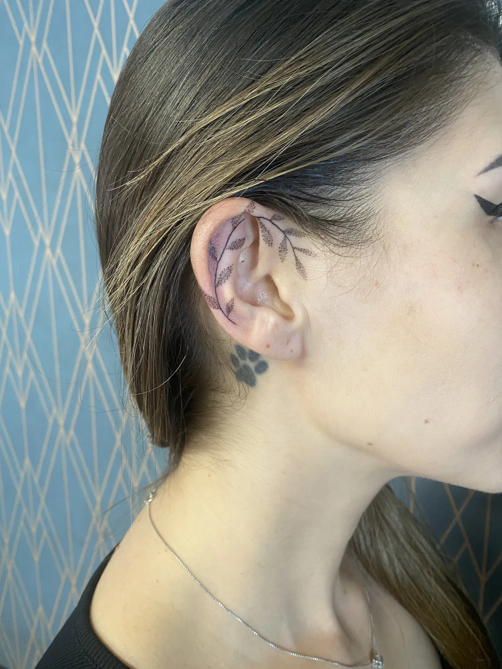 Tatouage branche fine line sur l'oreille et patte — Annahata