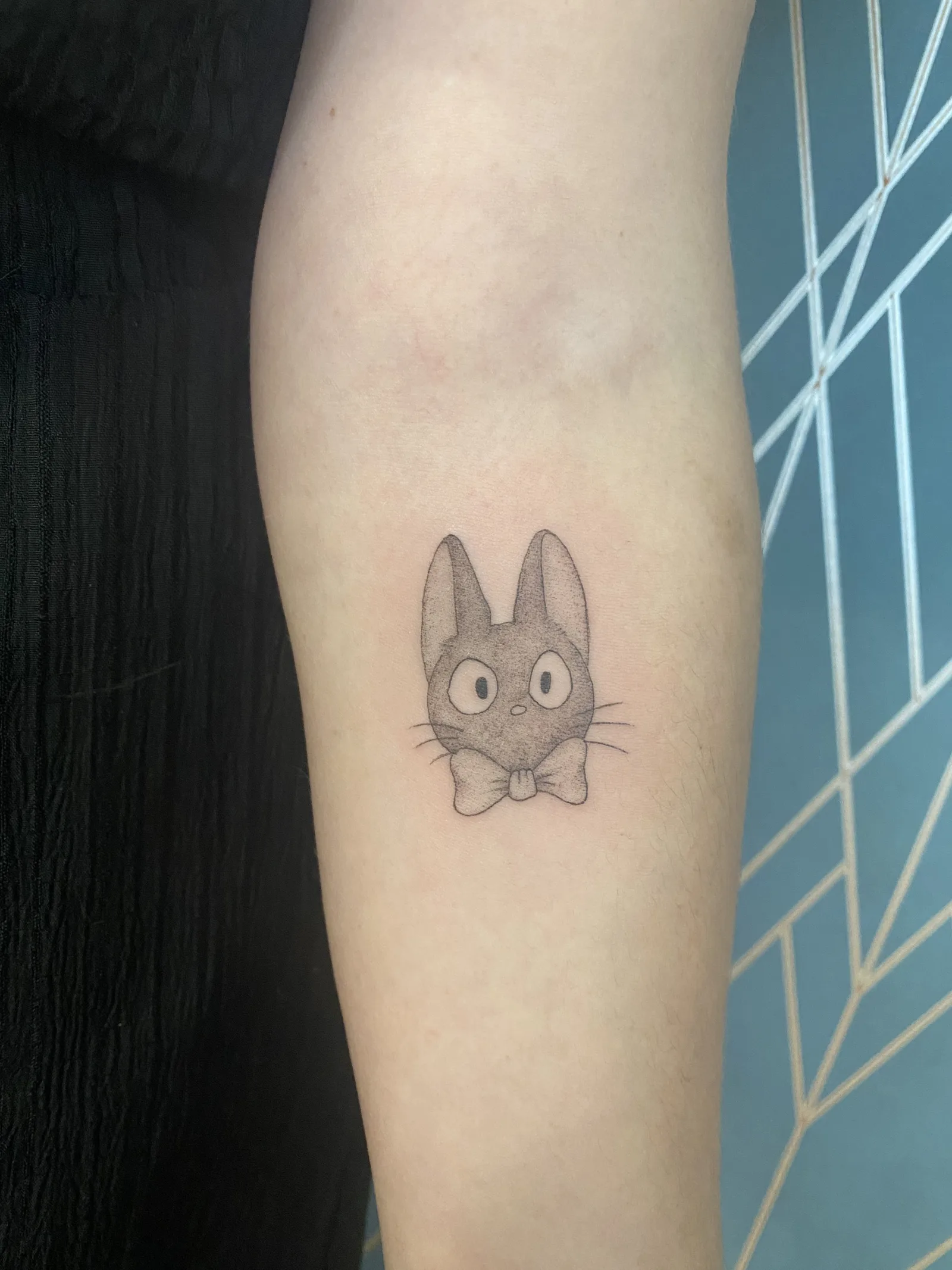 Tatouage chat Jiji fine line sur avant-bras — Annahata Tattoo