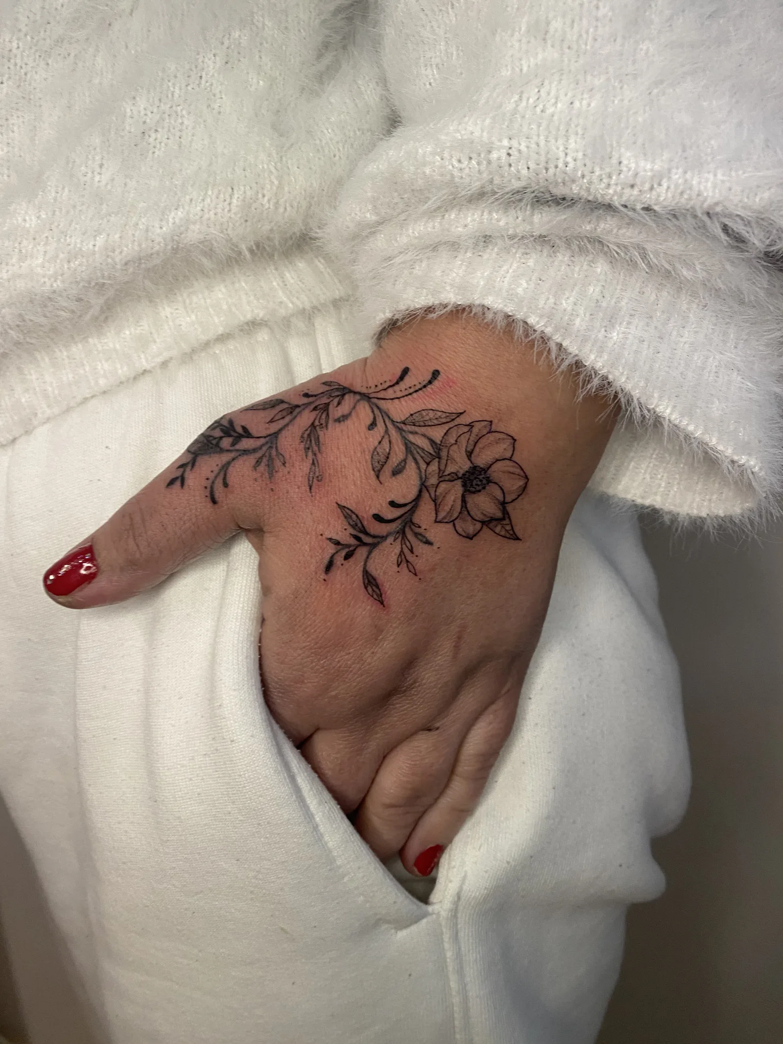Tatouage fleur anémone et vrilles fine line sur main — Annahata