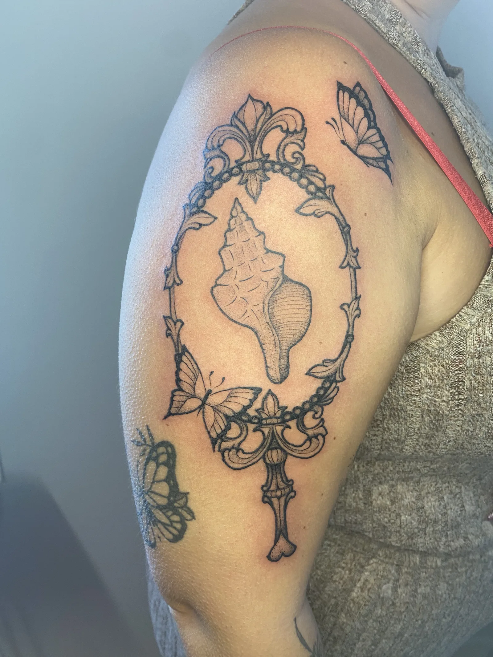 Tatouage miroir, coquillage et papillons fine line sur bras — Annahata