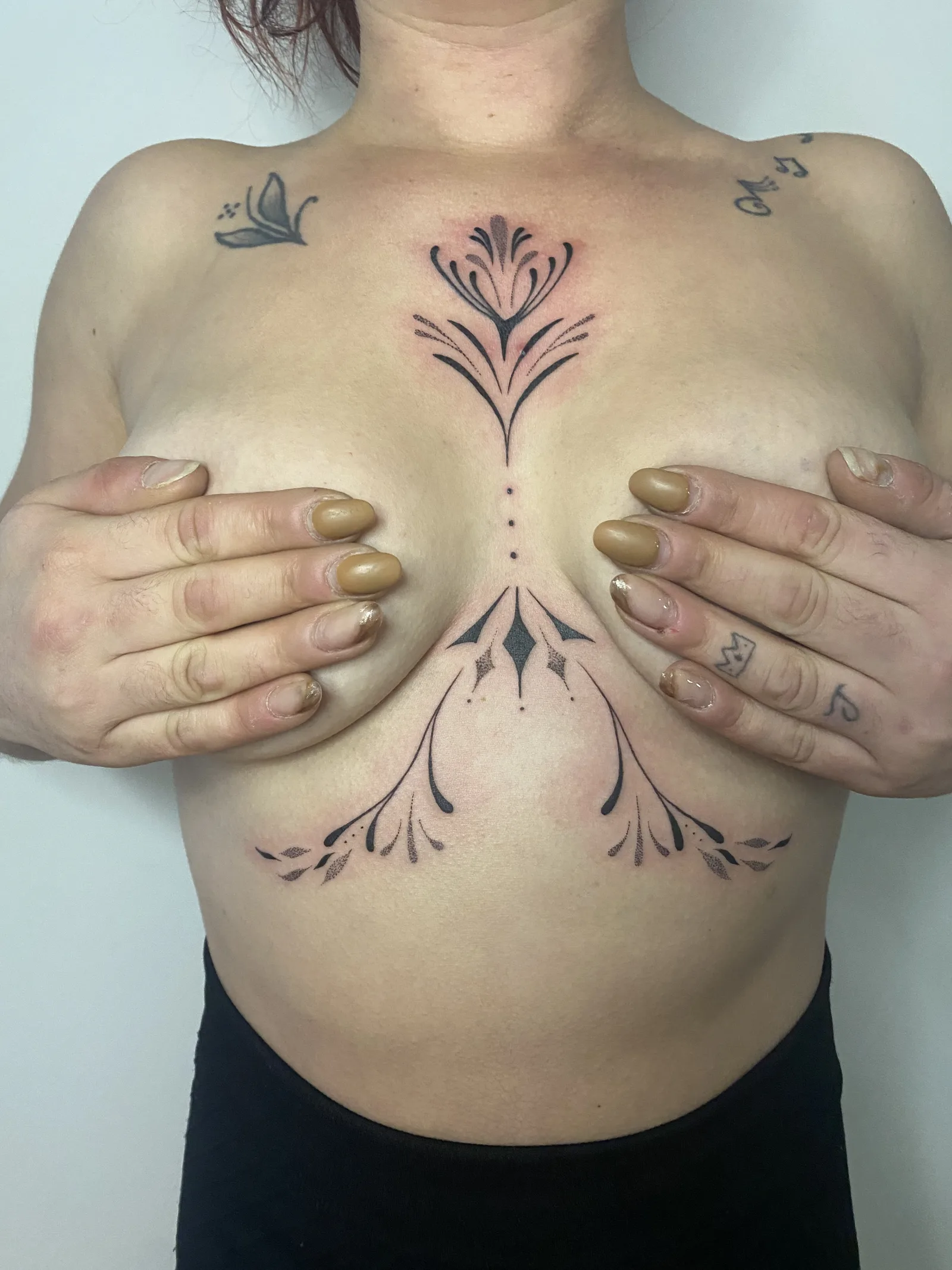 Tatouage ornemental sternum et sous-poitrine symétrique fine line — Annahata